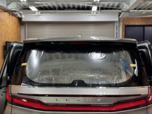 レクサスLMのリアガラスに合わせてフルメタルフィルムを熱成型している様子