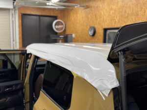 ランクル250 ファーストエディションのルーフへホワイトのラッピングフィルムを施工している様子