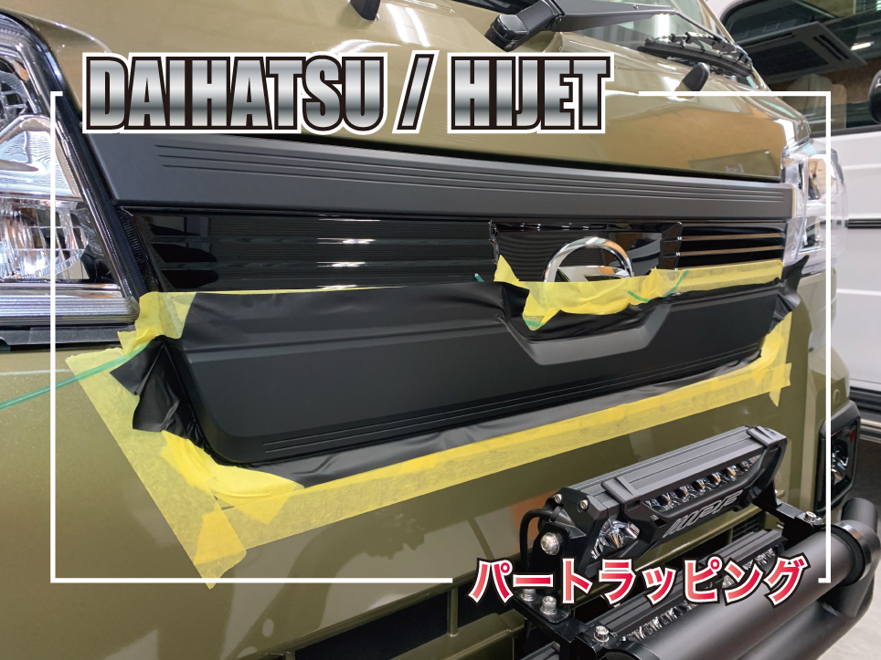 群馬のカーラッピング専門店でダイハツ・ハイゼットのフロントグリルをブラックでパートラッピング施工している様子