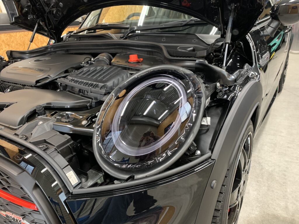 MINI F56 JCWのヘッドライトにプロテクションフィルムを施工中のアップ写真。