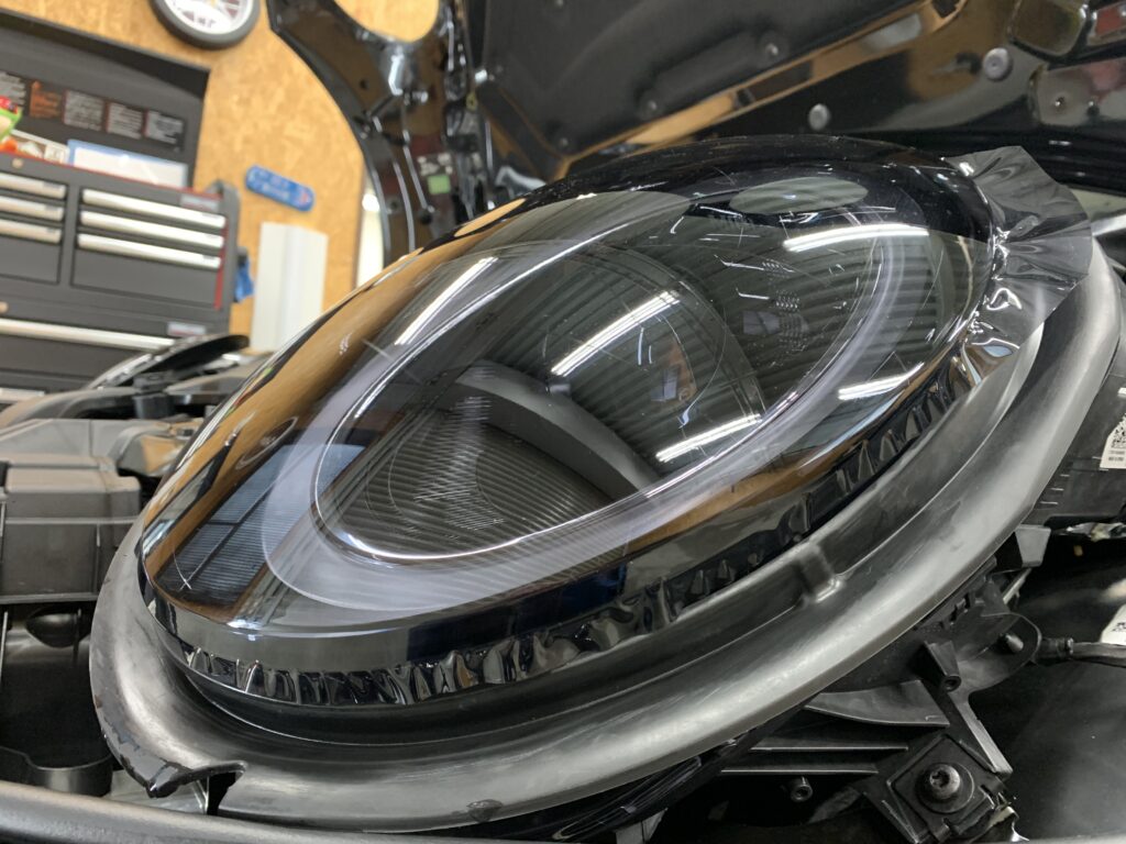 MINI F56 JCWのヘッドライトにスモークプロテクションフィルムを施工している作業中の接写。