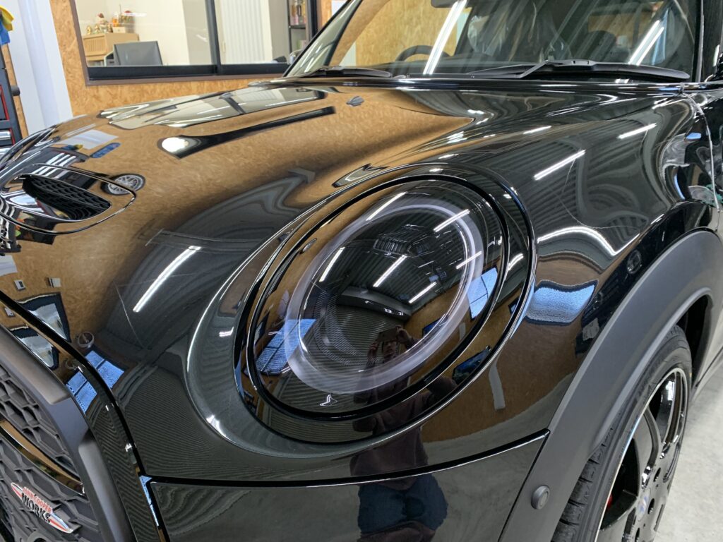 MINI F56 JCWのヘッドライトプロテクション施工後。黒いボディにヘッドライトの透明感が映えるフロント周りの写真