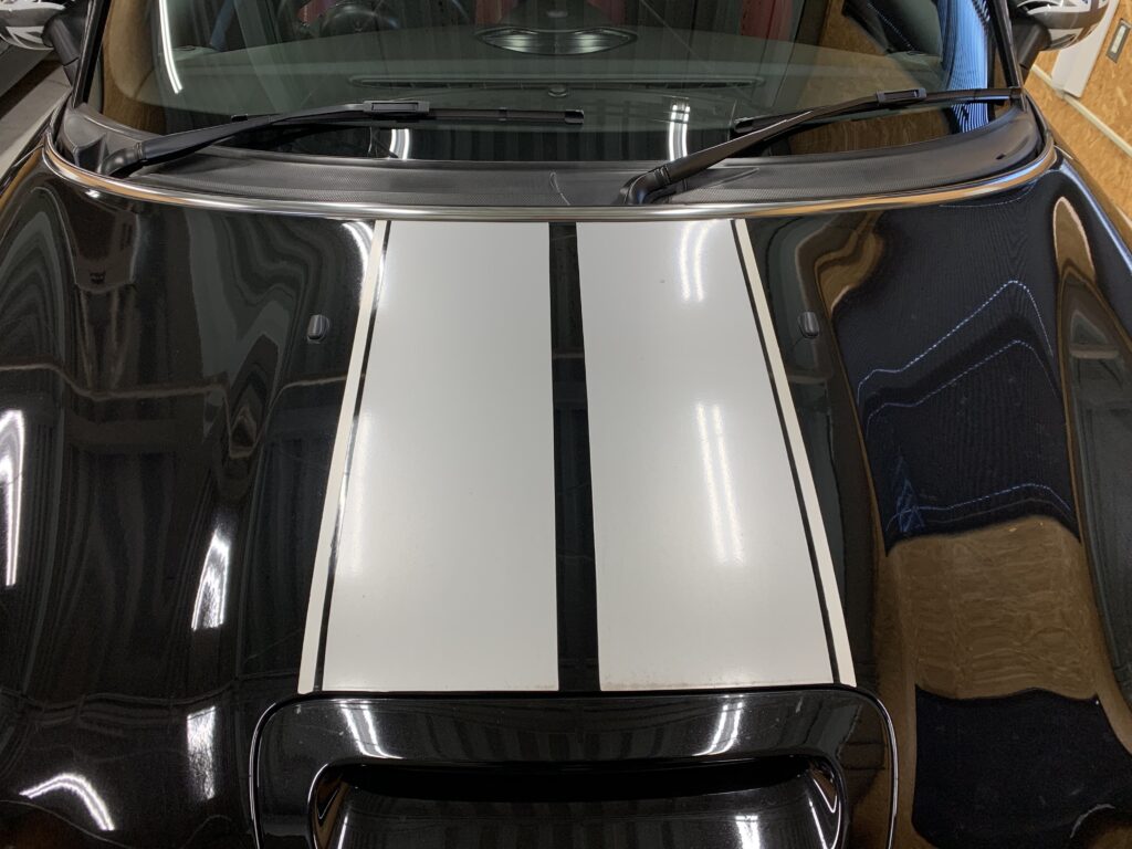 劣化したボンネットストライプが貼られたMINIクラブマン（R55）。色あせや汚れが見られる貼替前の状態。