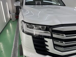 ランドクルーザー300のヘッドライトプロテクション施工風景。曲面に合わせて透明フィルムを密着施工している様子。