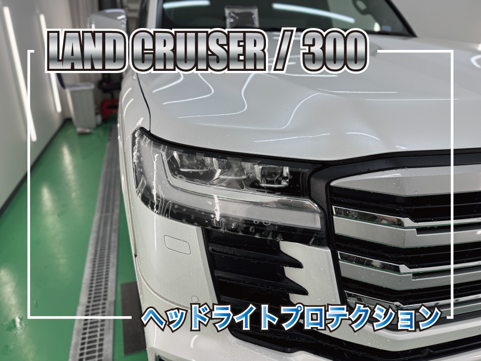 白いランドクルーザー300のフロントフェイス。ヘッドライトに透明プロテクションフィルムを施工している様子