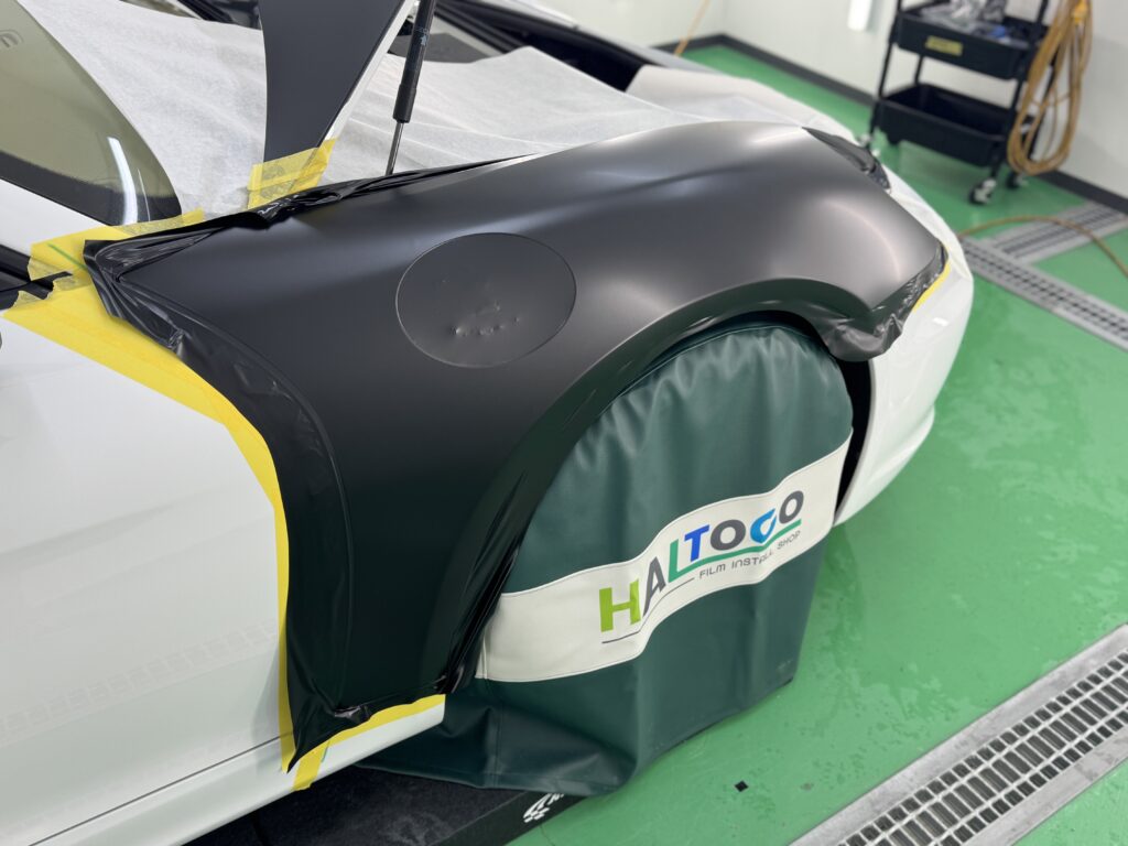 ポルシェ981型ボクスターのフロントフェンダーへ3Mサテンブラックを施工している様子