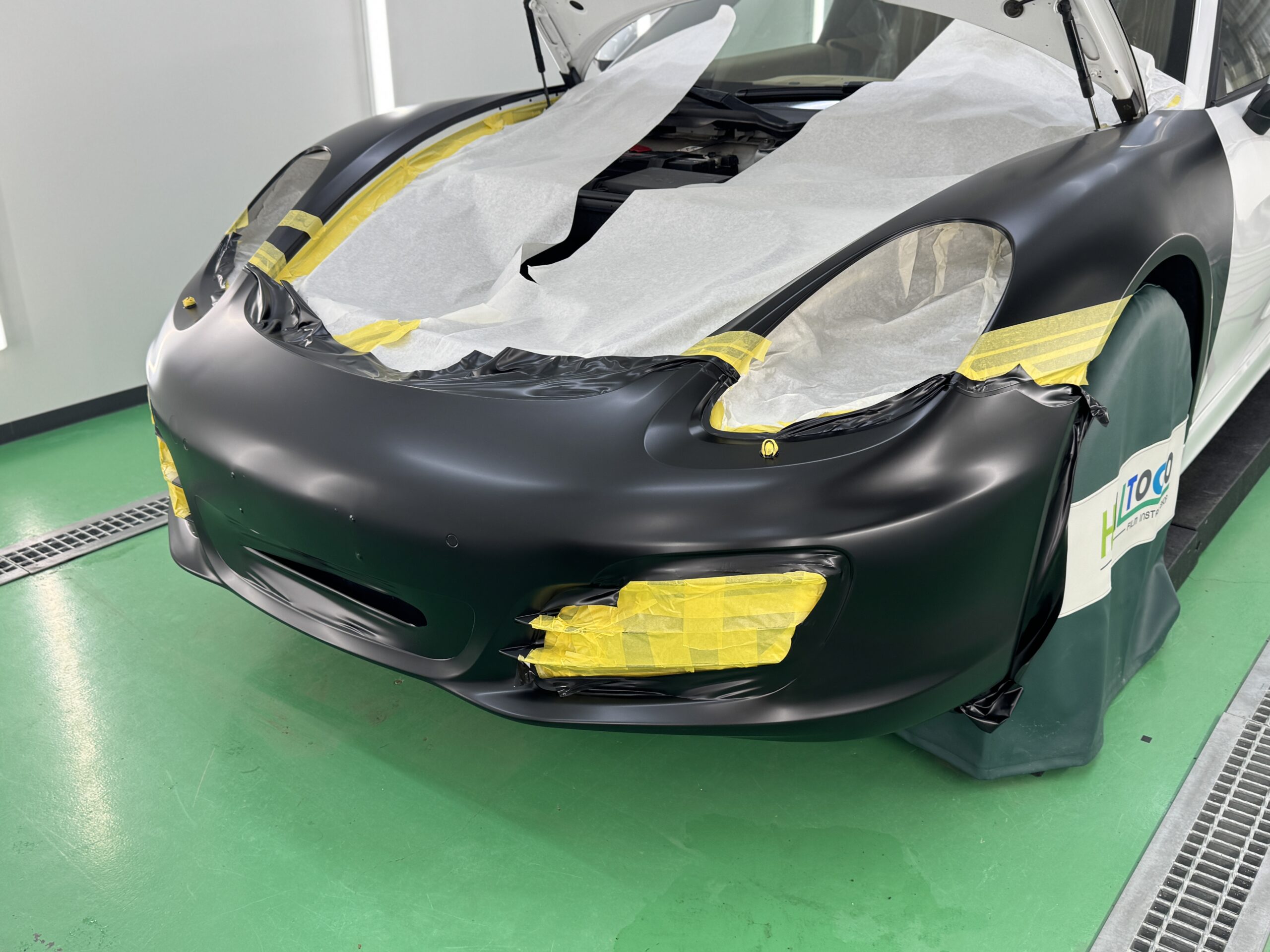 ポルシェ981型ボクスターのフロントバンパーを3Mサテンブラックでラッピング施工している様子