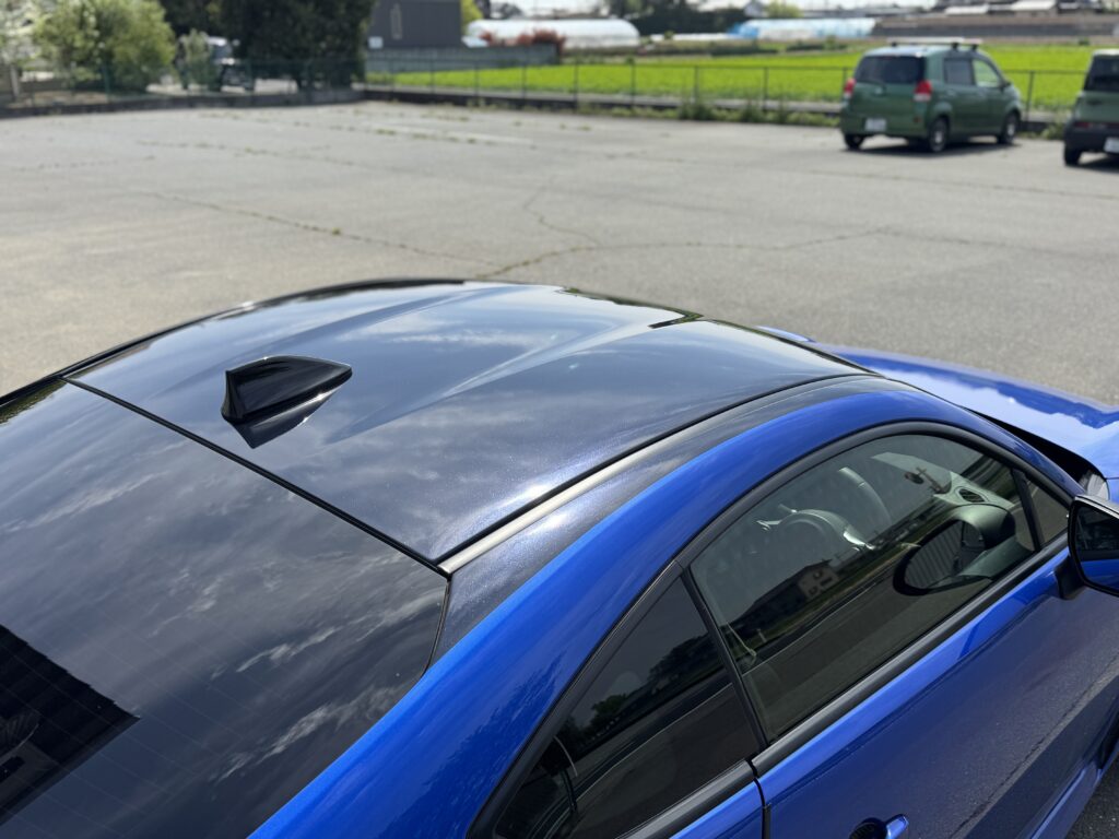 屋外で撮影したSUBARU BRZのルーフラッピング完成写真。青空が映り込むグロスブラックルーフがスポーティな印象を演出