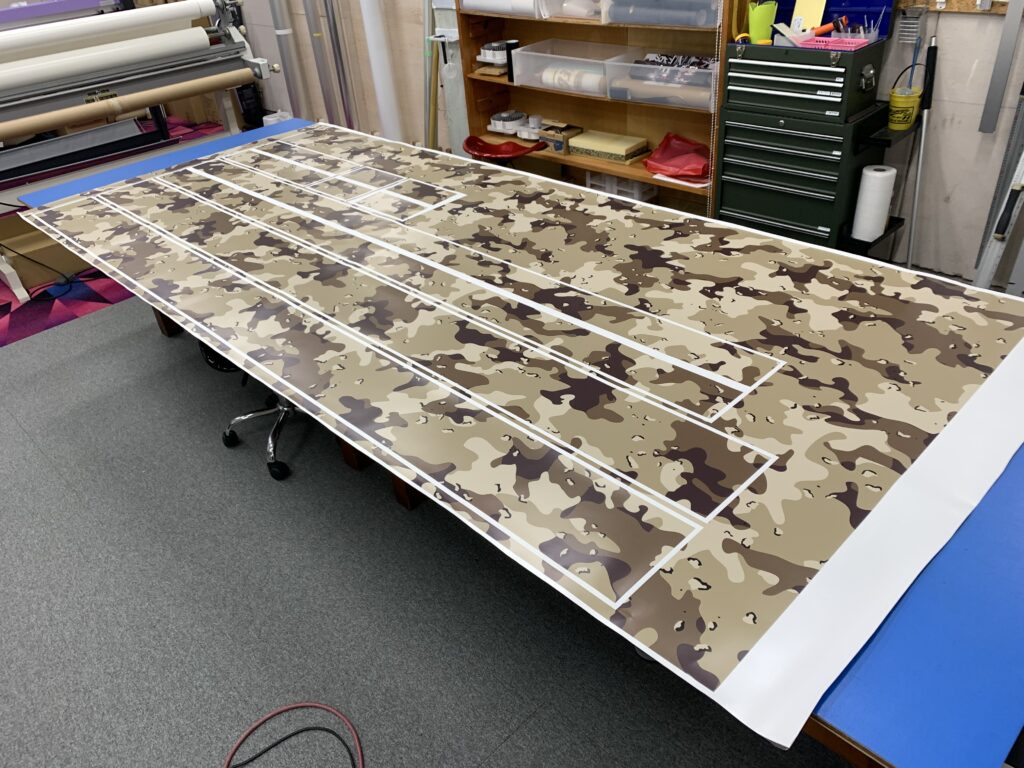 エブリィ用に製作したデザートカモ柄ストライプとサイドデカールを作業台に並べた様子