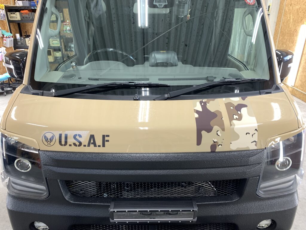 ベージュカラーのスズキ エブリィのボンネットにカモフラ柄ストライプとU.S.A.Fロゴを施工したフロントビュー