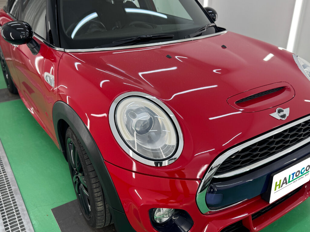 ヘッドライトプロテクション施工後の赤いMINIクーパーS。透明フィルム施工により純正デザインを維持しながら飛び石対策を実施。