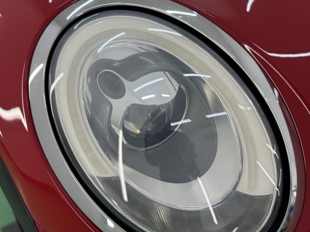 MINIクーパーSのヘッドライトへ透明プロテクションフィルム施工後のアップ写真。高い透明感で純正の質感を維持した仕上がり。