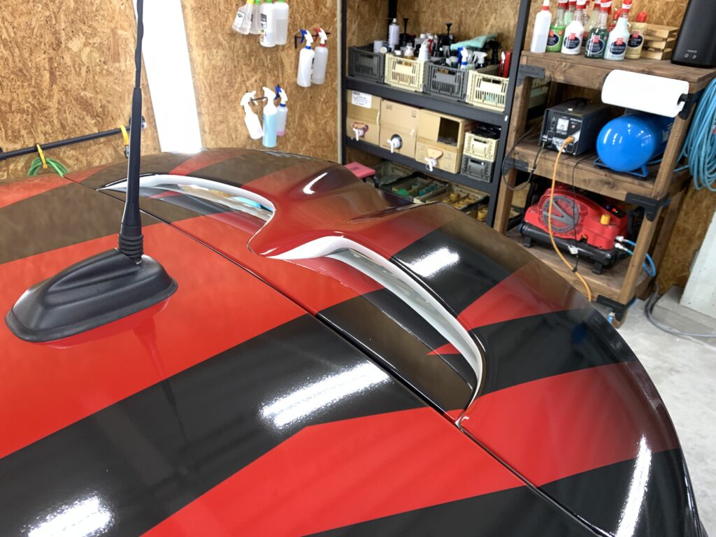 MINI F56 JCWの複雑な形状をしたリアスポイラー部分へ、CABANAデザインをモチーフにしたユニオンジャック柄ラッピングを施工した様子。立体的で入り組んだJCW専用スポイラーにもデザインのラインを自然につなげ、純正のような一体感のある仕上がりを実現している。