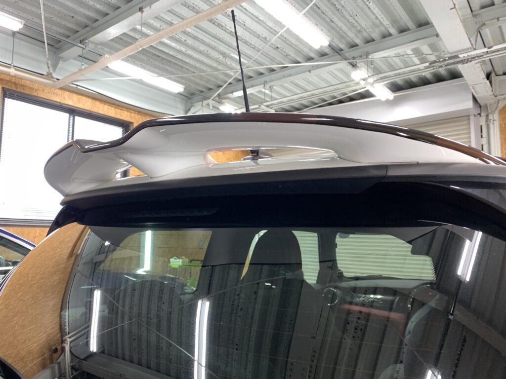 MINI F56 JCWの複雑な形状をしたリアスポイラー部分へ、CABANAデザインをモチーフにしたユニオンジャック柄ラッピングを施工した様子。立体的で入り組んだJCW専用スポイラーにもデザインのラインを自然につなげ、純正のような一体感のある仕上がりを実現している。