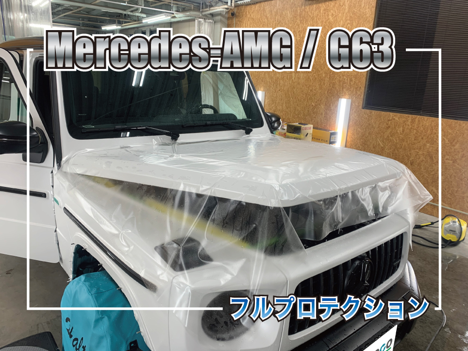 メルセデスAMG G63のフルプロテクション施工中の様子。ボンネットからフロント周りにかけて大判のプロテクションフィルムを施工している作業風景。ホワイトボディのG63に透明フィルムを貼り込みながら塗装面を保護している。