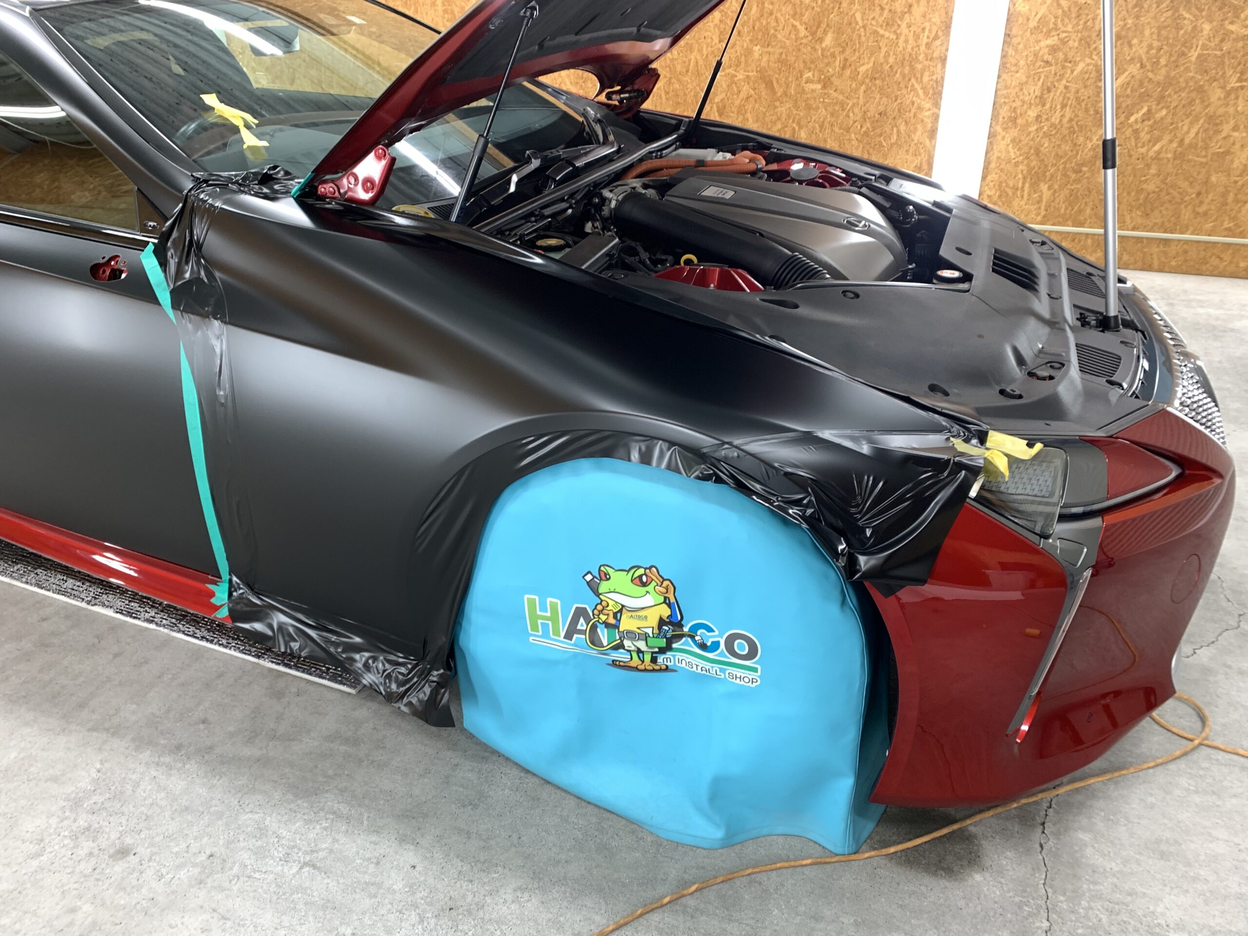 レクサスLC500hのフロントフェンダーへ3Mサテンブラックを施工している様子。ボディラインに合わせてフィルムを成形している工程写真