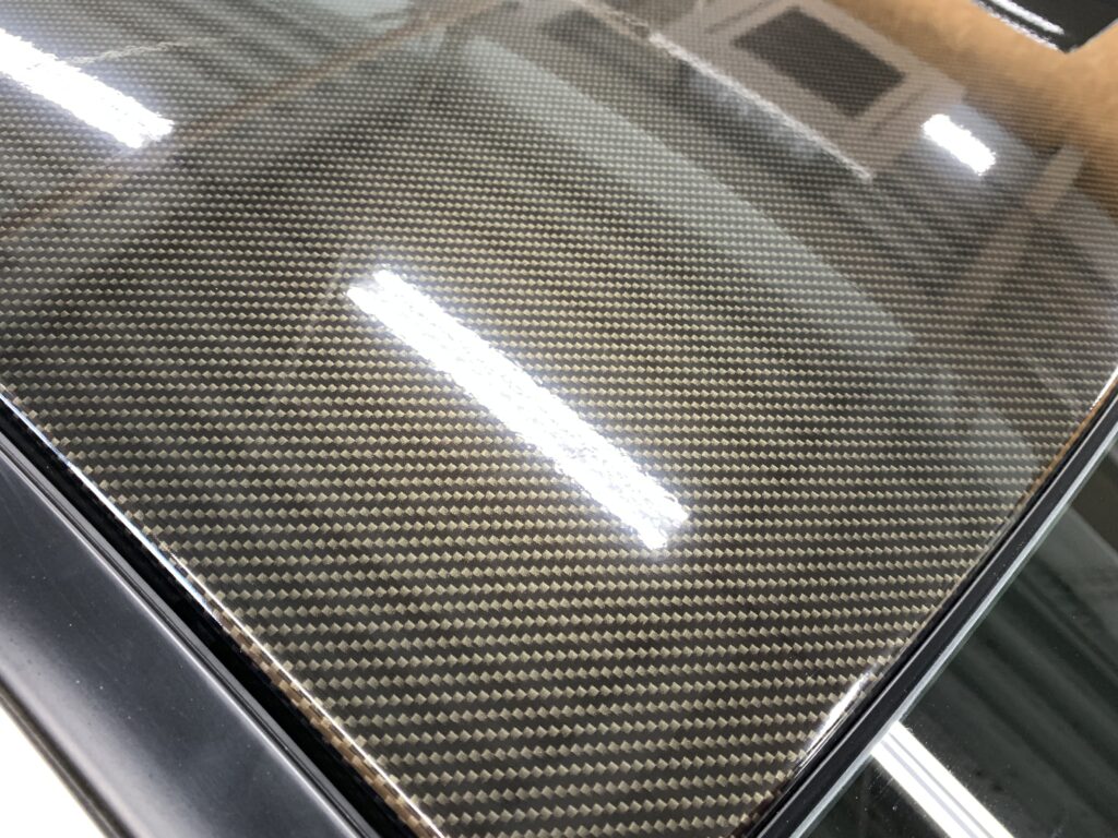 TECKWRAP RCF03カーボン柄フィルムの質感を近距離で撮影した写真。細かな織り目模様と高い艶感が確認でき、リアルカーボンのような立体感を表現している。