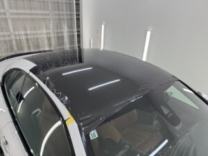 BMW M4カブリオレのルーフへLDカーボンメタリックフィルムを施工している様子