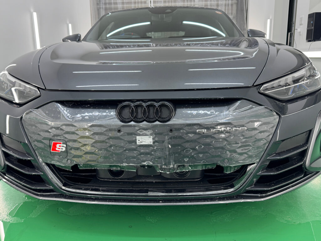 Audi e-tron GTのフロントグリルにPPFを水張りで施工している様子
