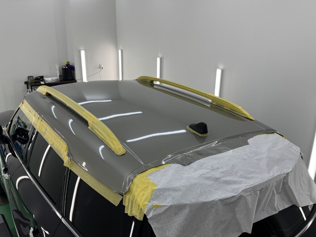 MINIクロスオーバーのルーフへカーラッピングフィルムを施工している作業風景