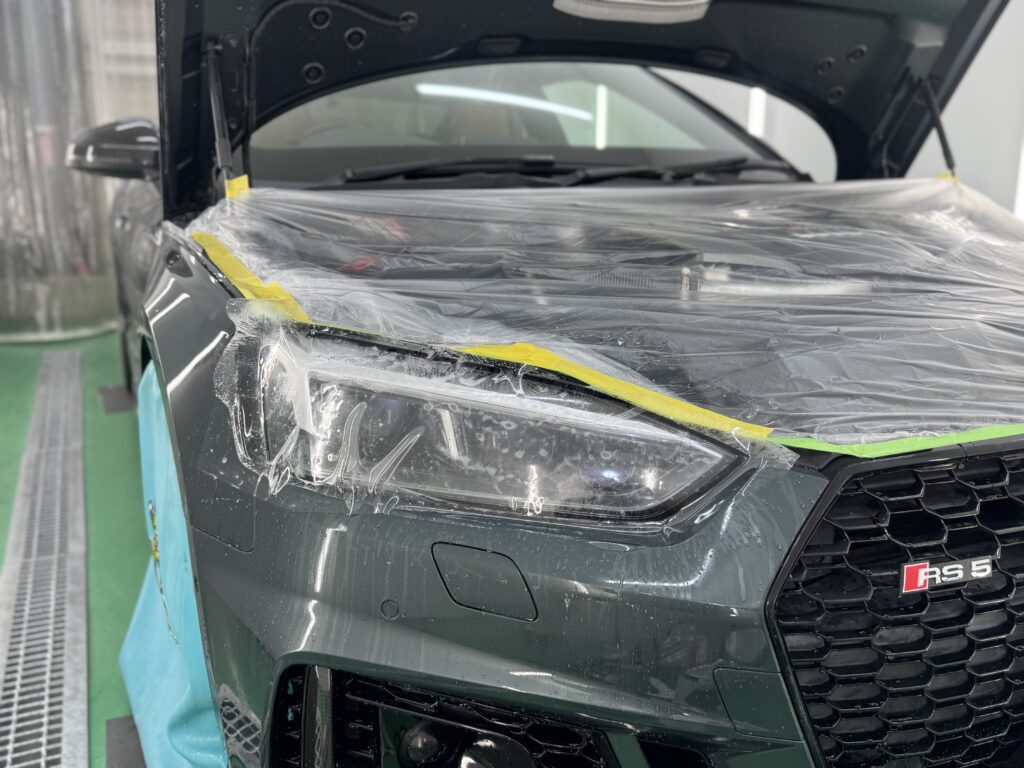 Audi RS5のヘッドライトにプロテクションフィルムを施工している様子