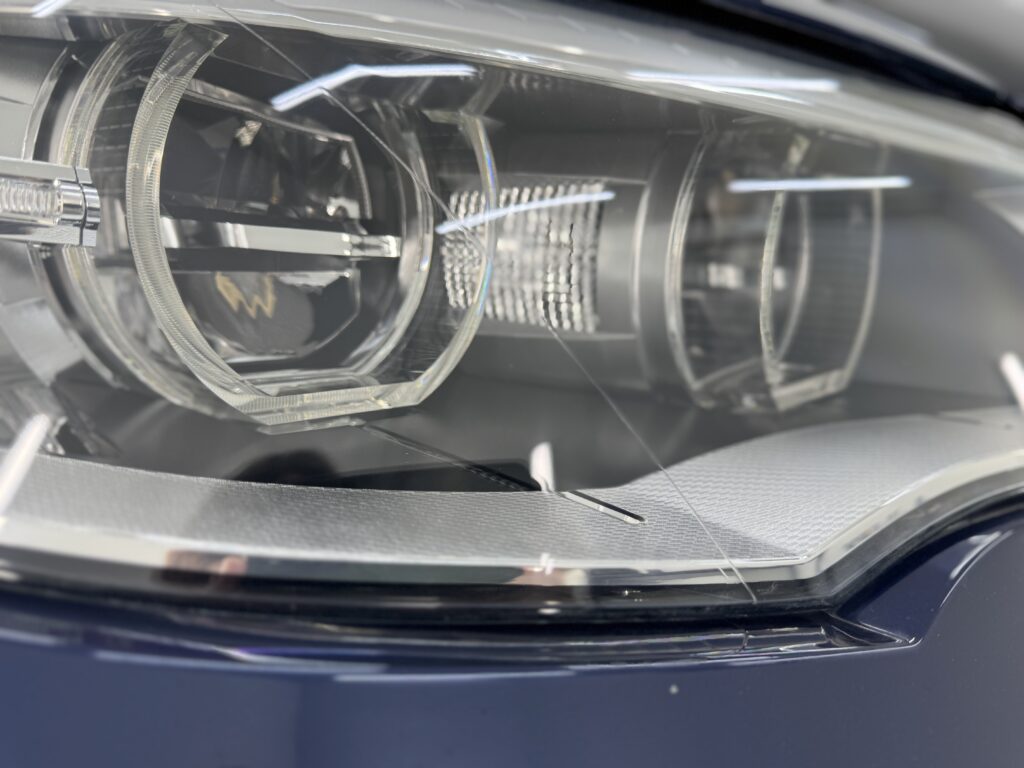BMW X6ヘッドライトリペアとPPF施工後の近接写真、細部までクリアに仕上がった状態