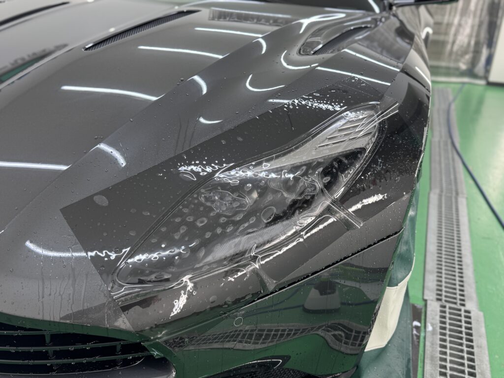 アストンマーティン DB11 ヘッドライトへスモークPPF施工中