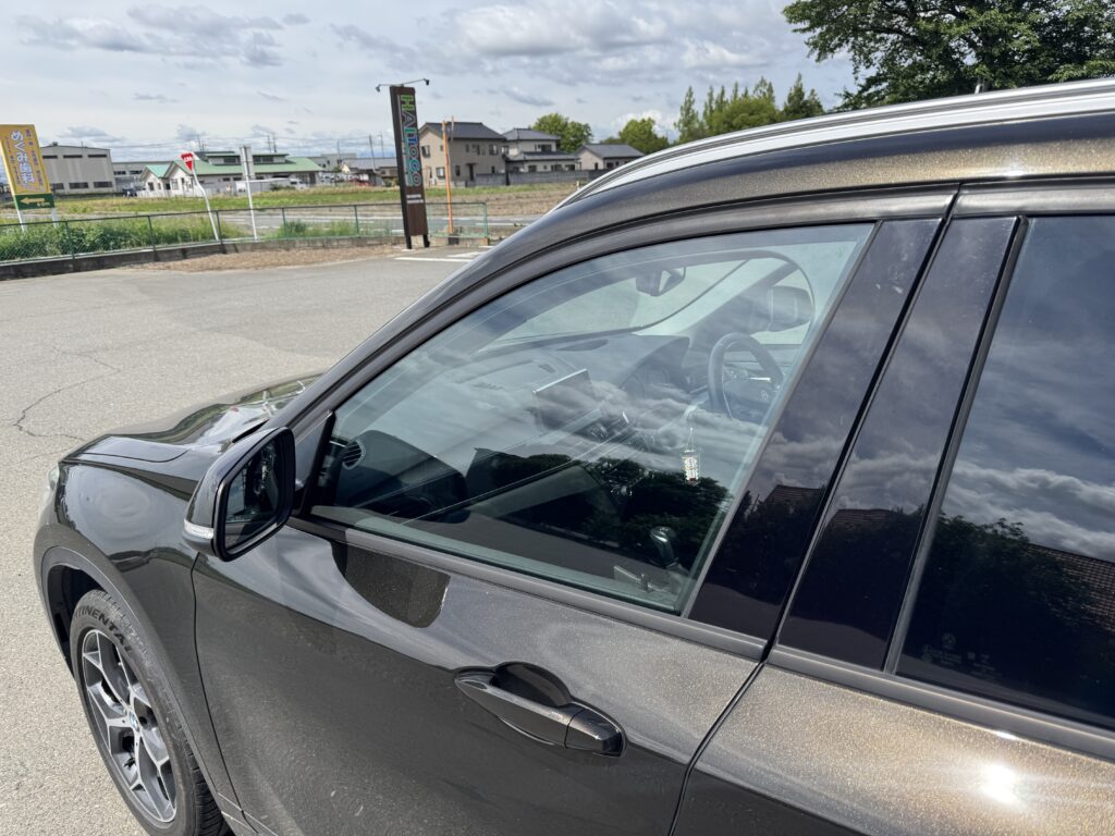 透明断熱フィルム施工後のBMW X1を屋外で確認したフロントドアガラス