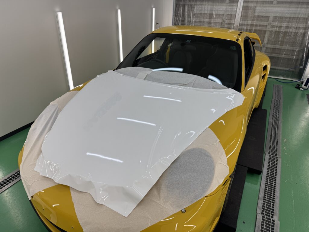 ポルシェ911 Turbo(997.1)のボンネットにグロスホワイトのラッピングフィルムを施工している様子