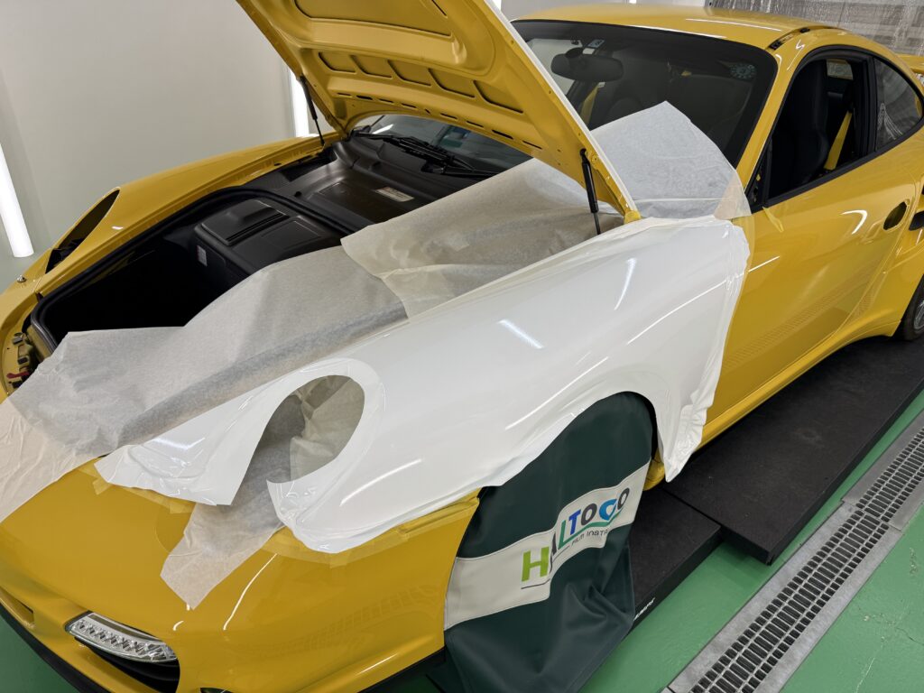 ポルシェ911 Turbo(997.1)のフロントフェンダーにグロスホワイトのラッピングフィルムを施工している様子