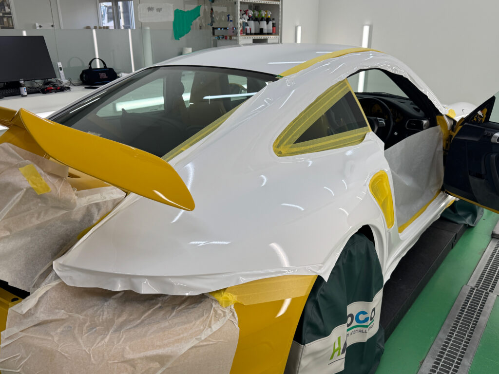 ポルシェ911 Turbo(997.1)のワイドなリアフェンダーをグロスホワイトでラッピング施工している様子