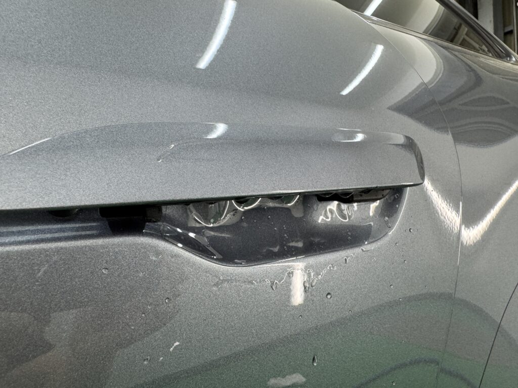 ポルシェ911 Carreraのドアカップに透明プロテクションフィルムを施工している様子