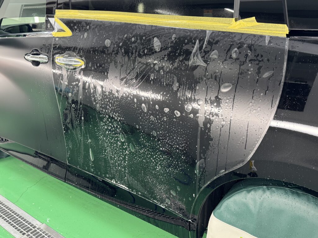 トヨタ アルファードのスライドドアにXPEL STEALTHを施工している様子