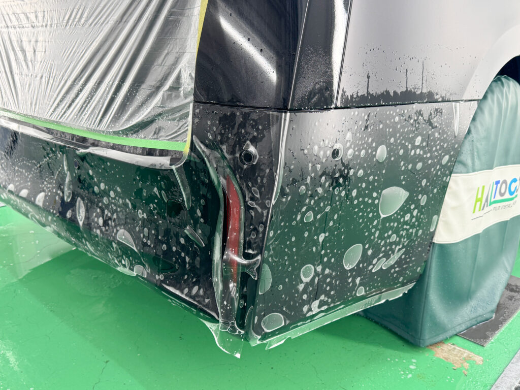トヨタ アルファードのリアバンパーにXPEL STEALTHを施工している様子