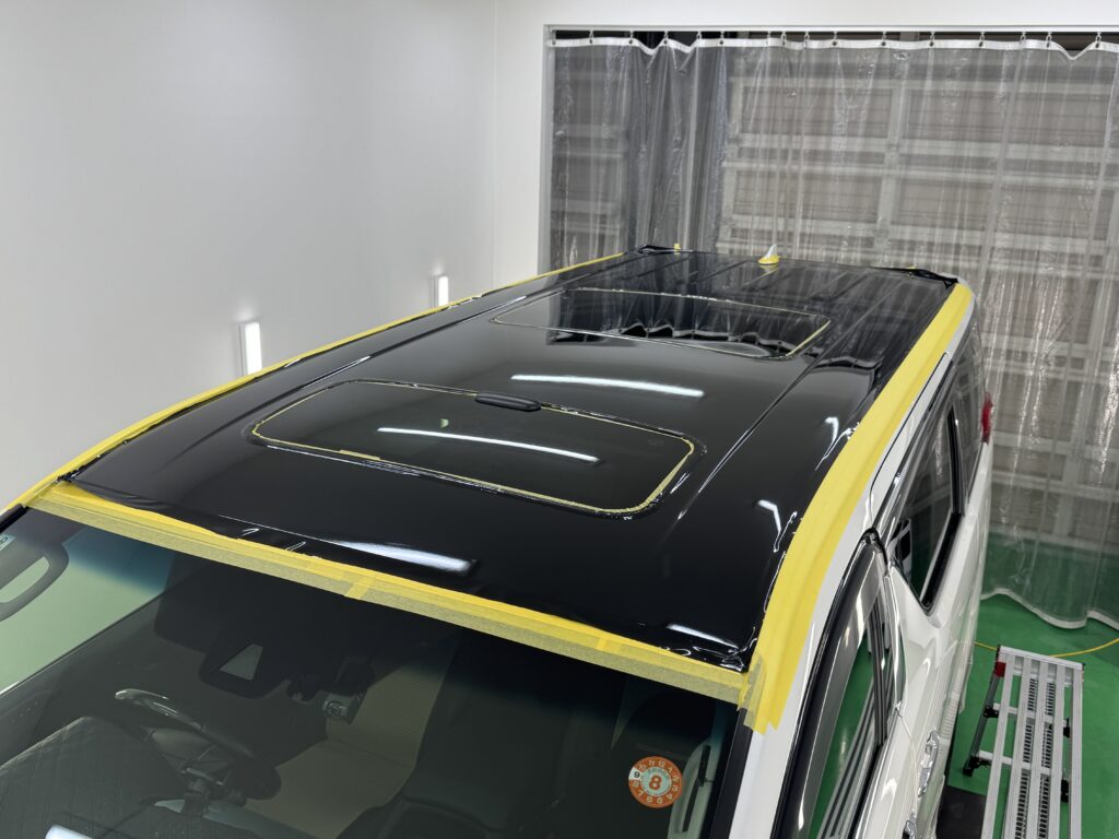 トヨタ アルファードのルーフにブラックフィルムを施工中