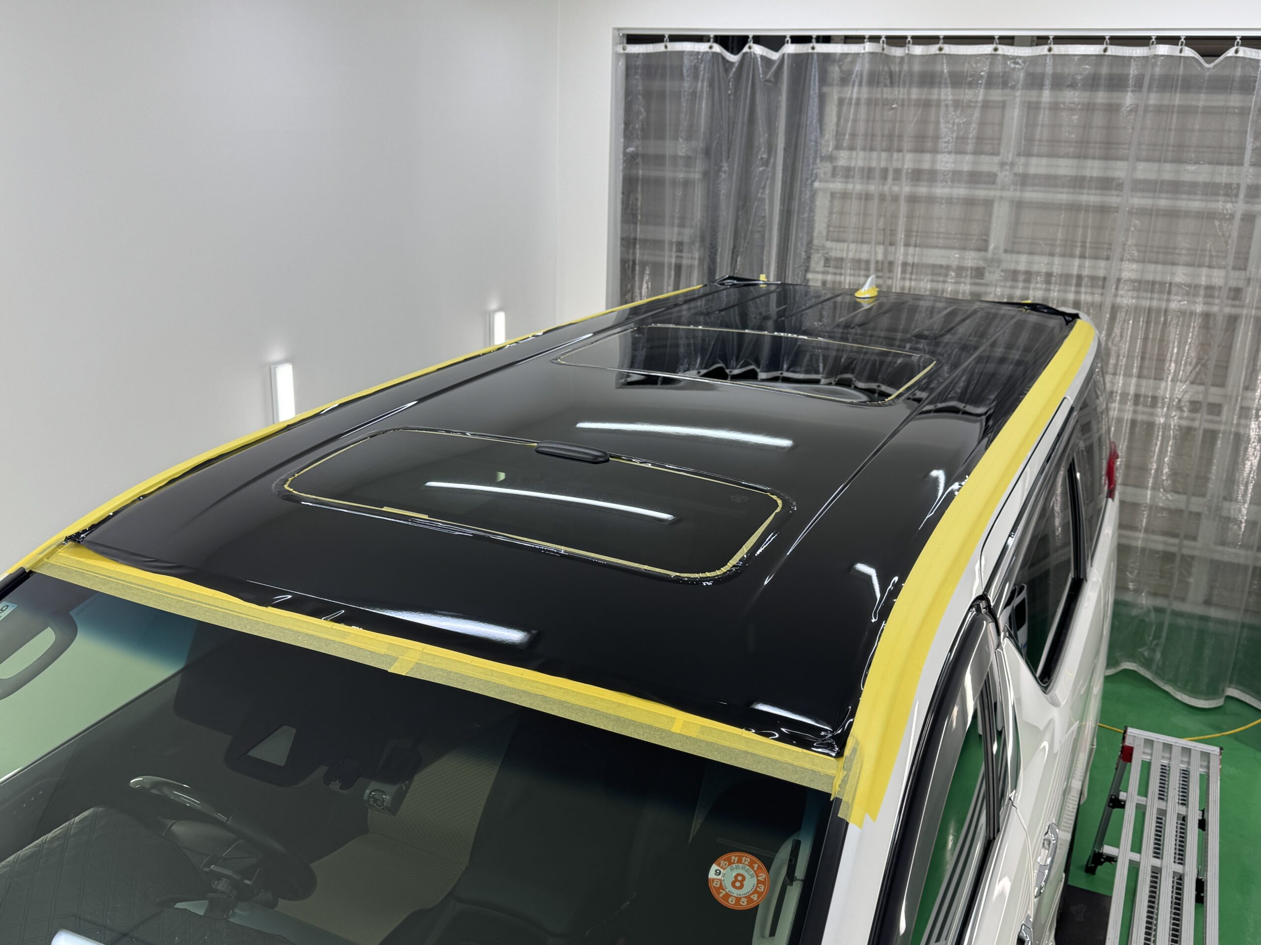 トヨタ アルファードのルーフにブラックフィルムを施工中