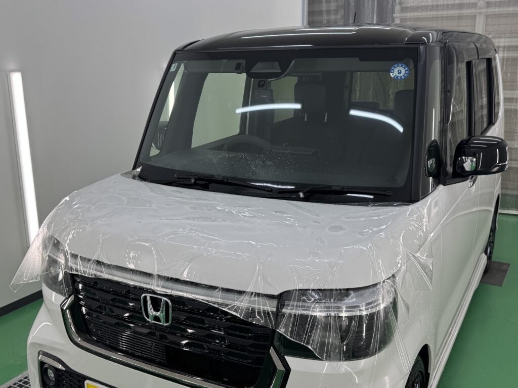 ホンダ N-BOXのボンネットにプロテクションフィルムを施工している様子