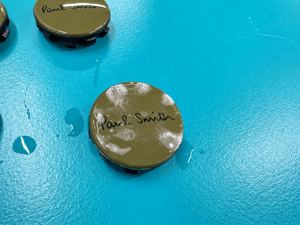 Paul Smithロゴ入りホイールセンターキャップへの透明プロテクションフィルム施工中