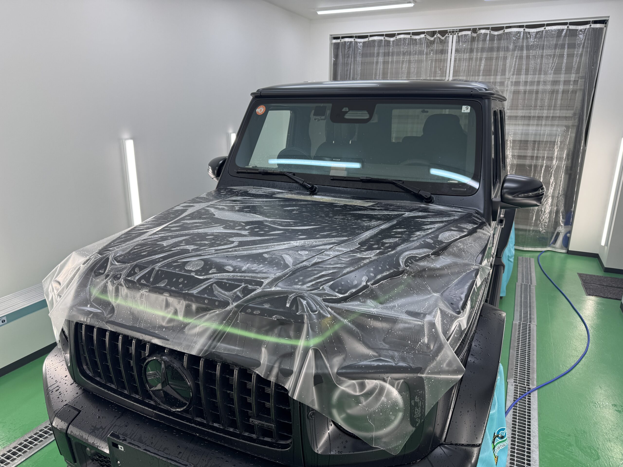 メルセデスAMG G63 Black Accent Editionのボンネットにマットプロテクションフィルムを貼り付けている施工中の様子