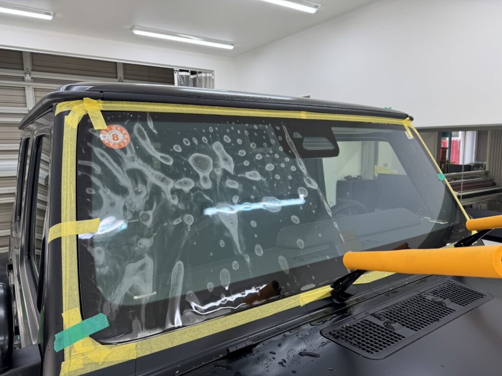 G63のフロントガラスにウインドウプロテクションフィルムを施工している様子