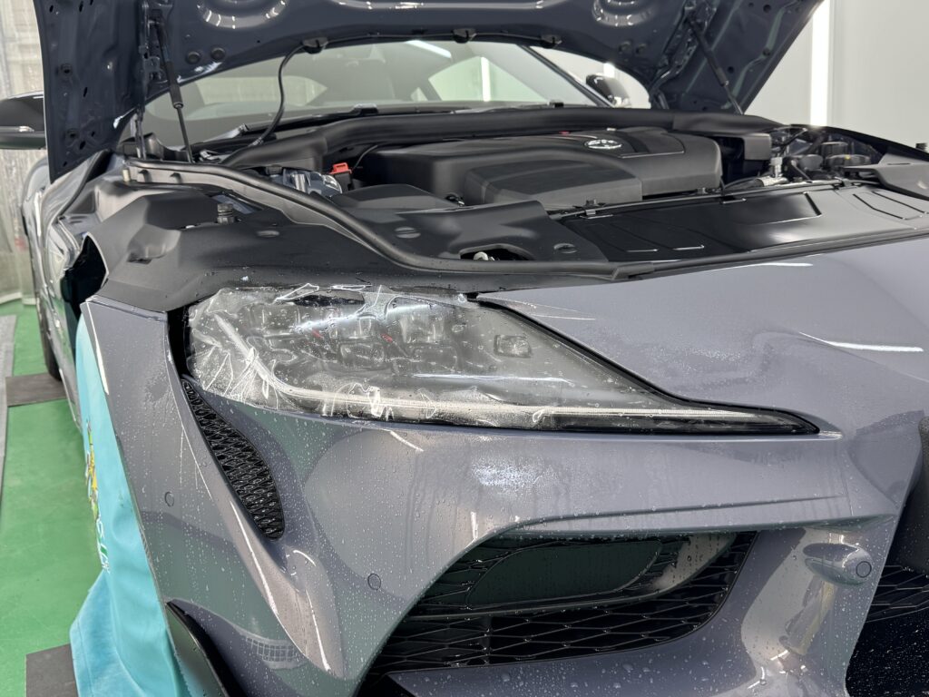 トヨタ GRスープラのヘッドライトにプロテクションフィルムを施工している様子