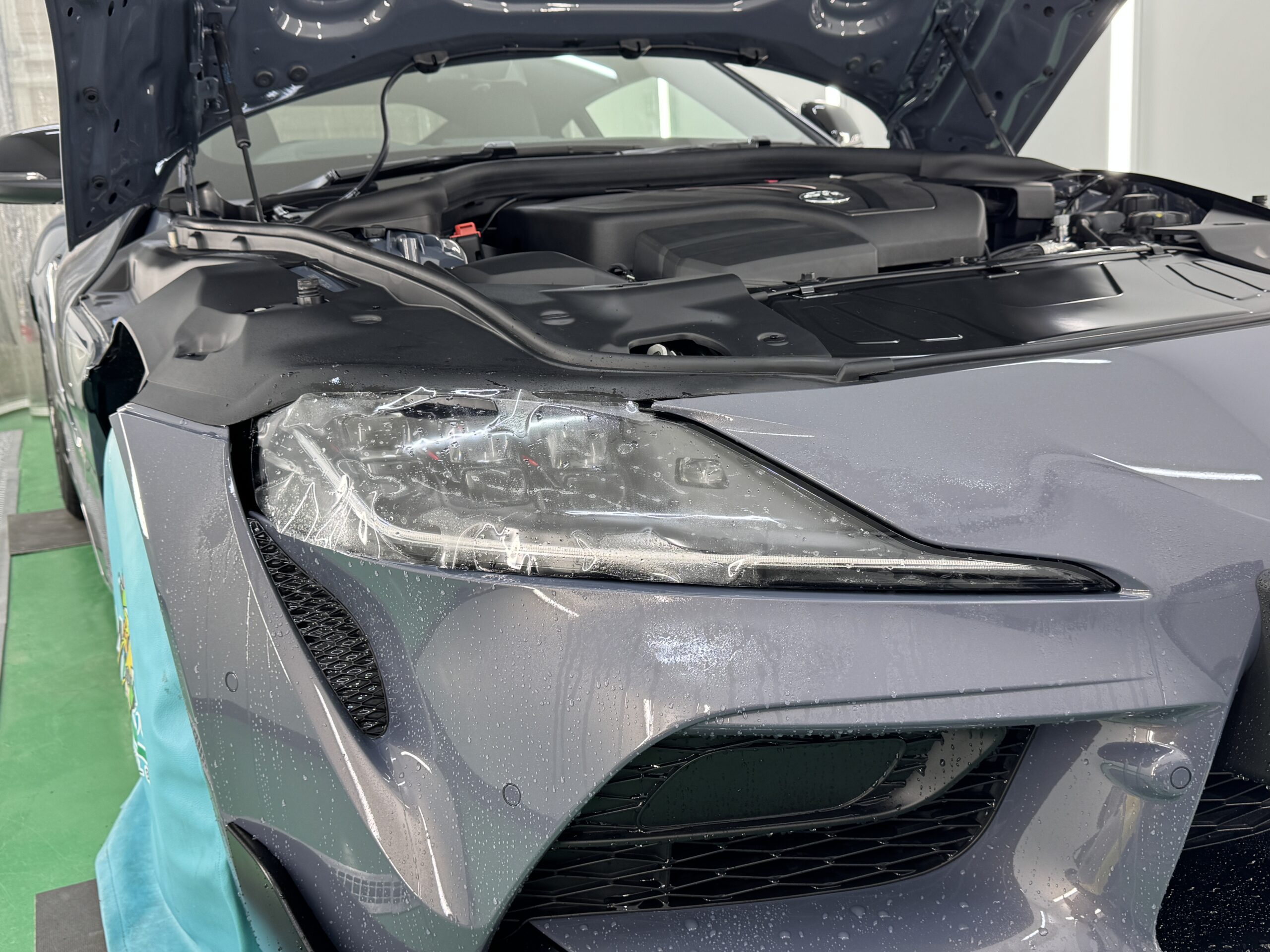 トヨタ GRスープラのヘッドライトにプロテクションフィルムを施工している様子