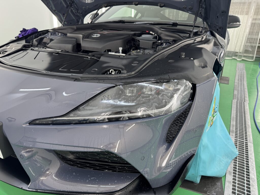 トヨタ GRスープラのヘッドライトへプロテクションフィルムを施工している様子