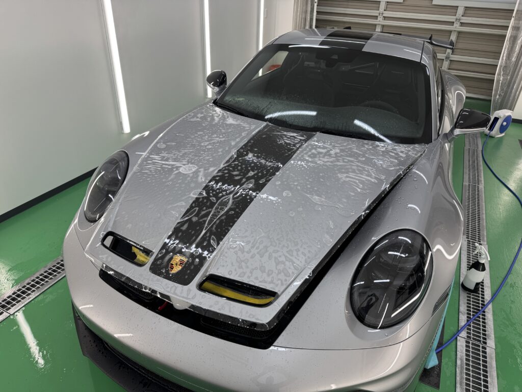 ポルシェ 911 GT3のボンネットにプロテクションフィルムを施工している様子