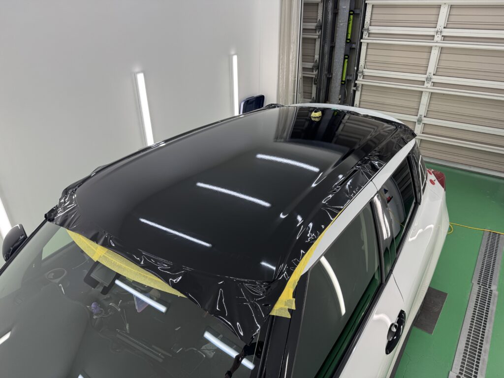 スズキ スイフトのルーフ全面へグロスブラックフィルムを施工している途中